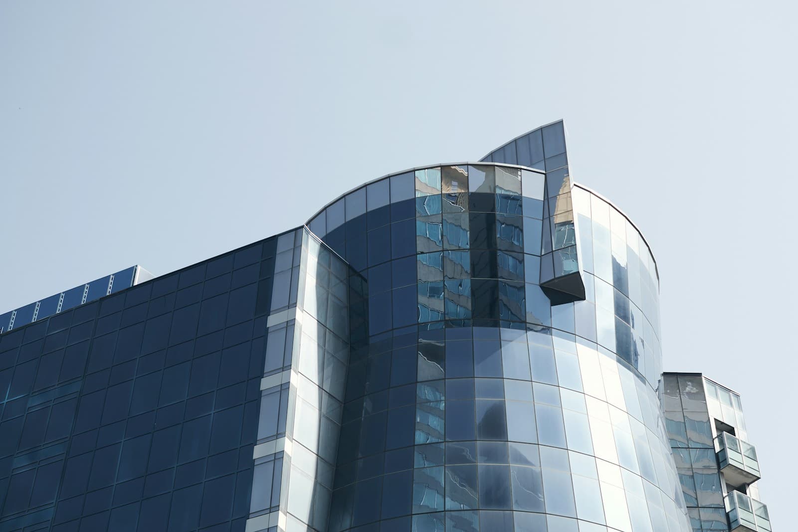 Modern glass-clad office tower against a clear sky